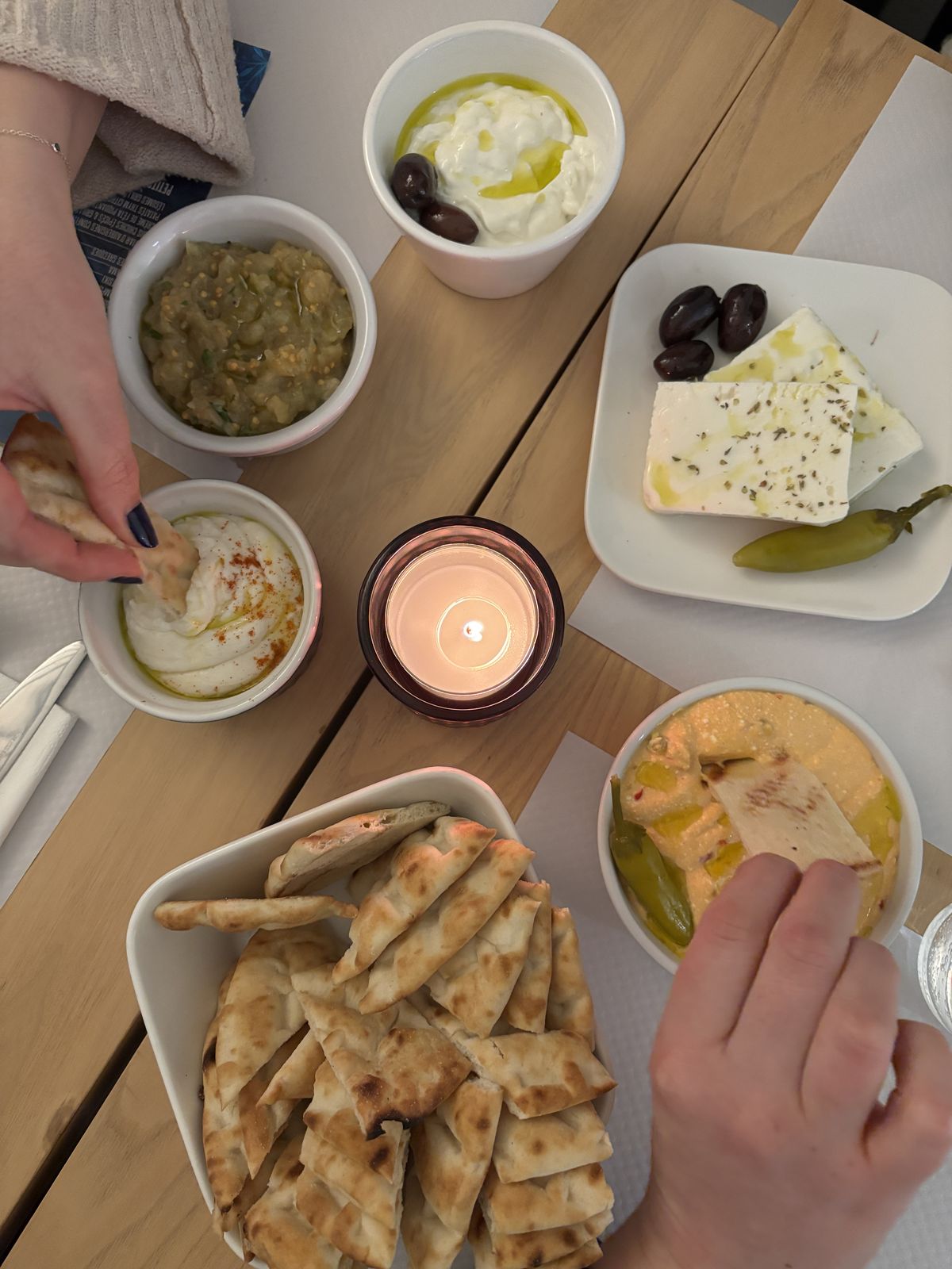 Table de mezzes partagés : tzatziki, caviar d'aubergines, xtipiti, fêta et pain pita