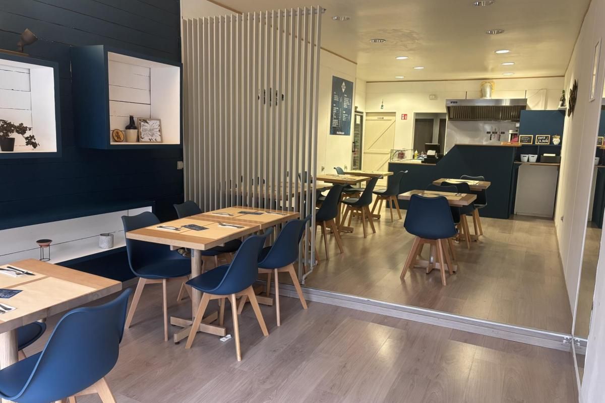 Vue d'ensemble de la salle de Kalos avec la cuisine ouverte au fond